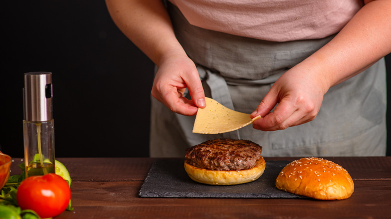 putting slice of cheese on burger