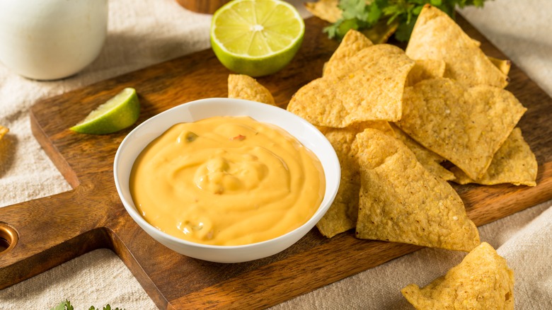 bowl of nacho cheese with chips