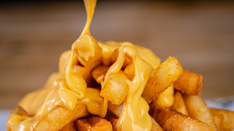 drizzling melted cheese on fries