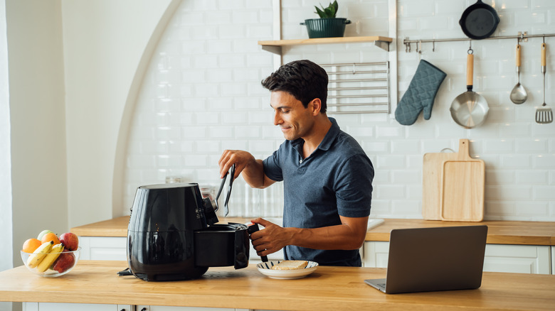 man opening air fryer