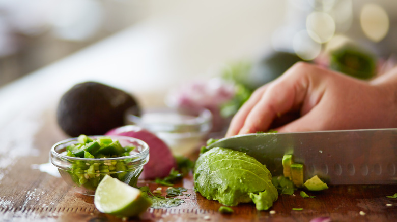 hand slicing avocado for guacamole