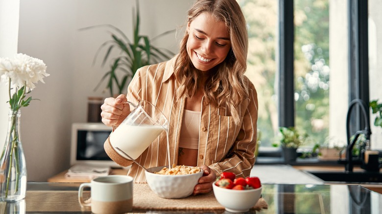 woman pouring milk in bowl