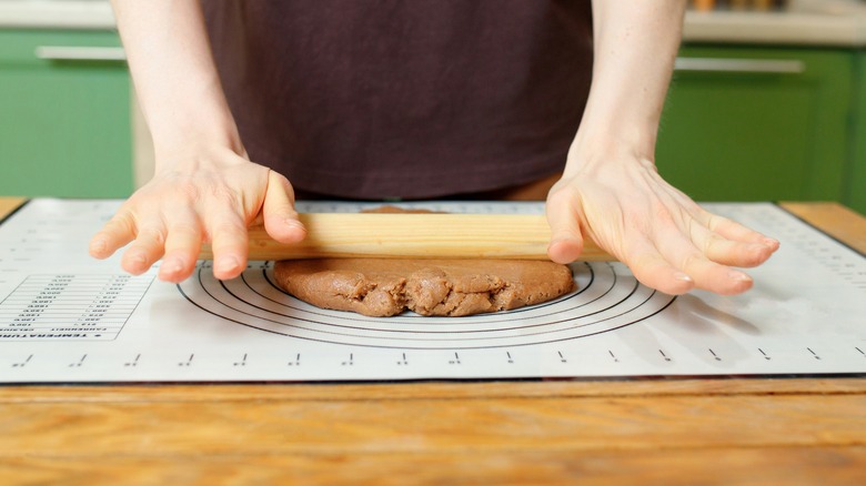 Hands rolling out gingerbread dough