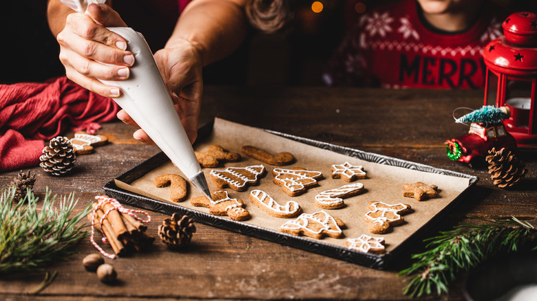 Icing gingerbread cookies on table