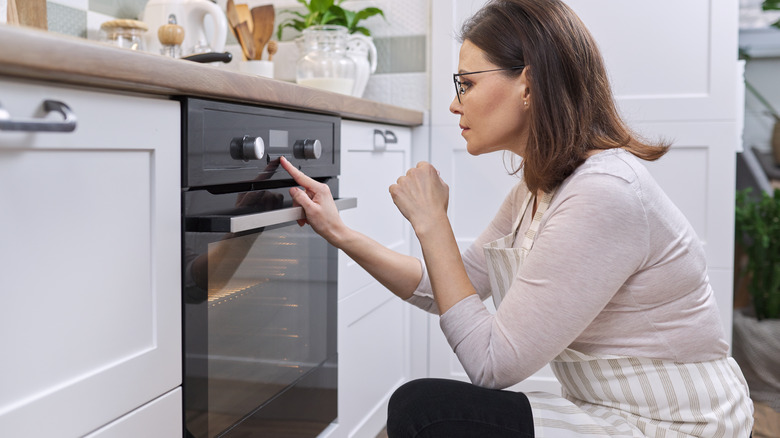 Woman adjusting oven settings