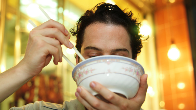 person holding chopsticks near bowl