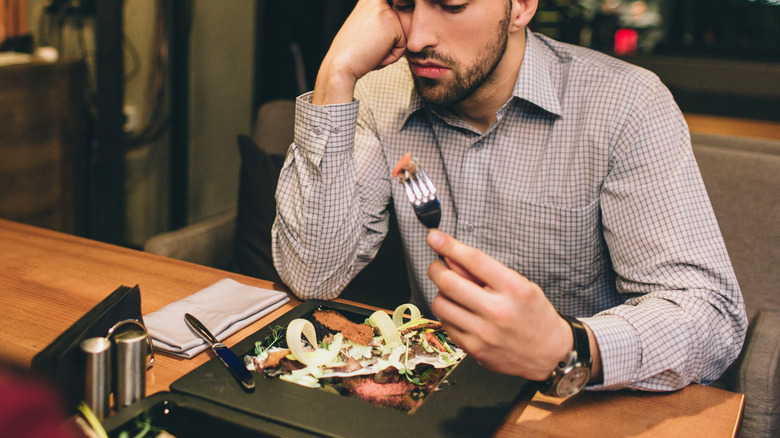 bored man holding a fork