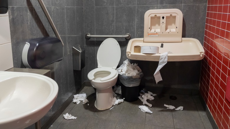 dirty restroom with paper everywhere