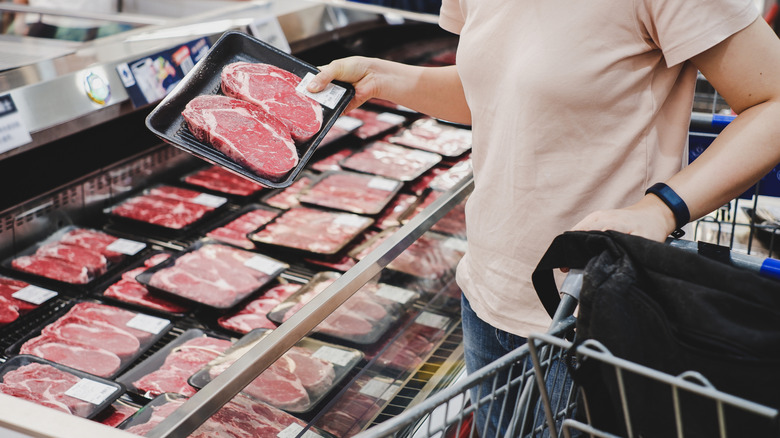 Woman holding package of meat