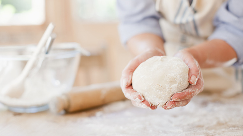 Hands holding dough