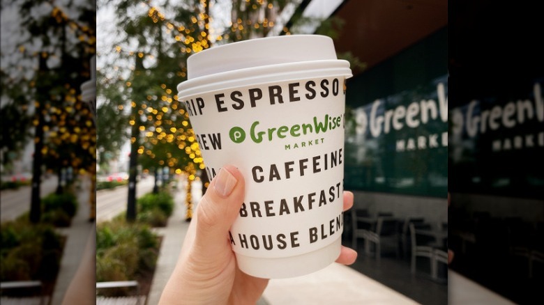 To go coffee cup held in the air 