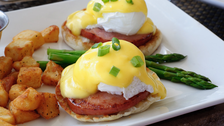 eggs benedict, hollandaise sauce, yellow, potatoes, white plate, asparagus