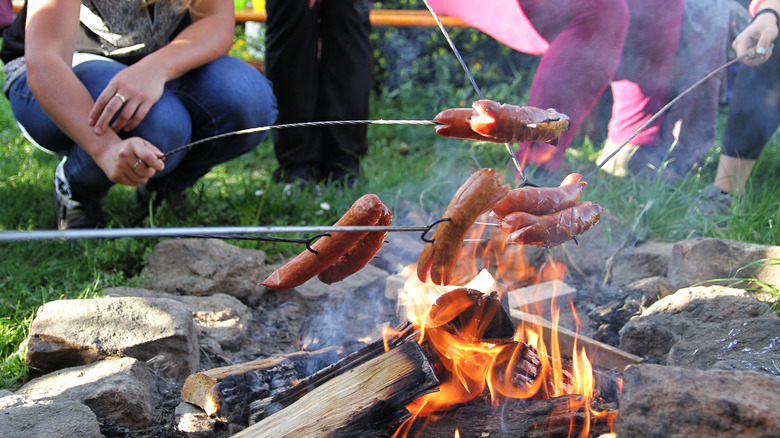 Split hot dogs over campfire