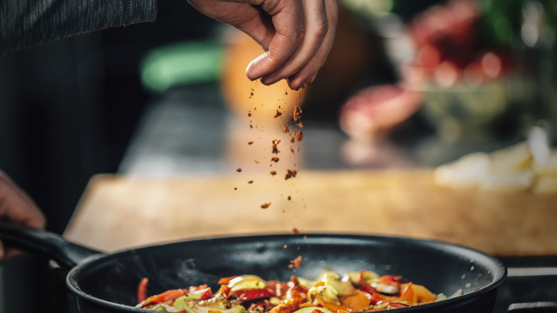 Chef adding paprika to pan