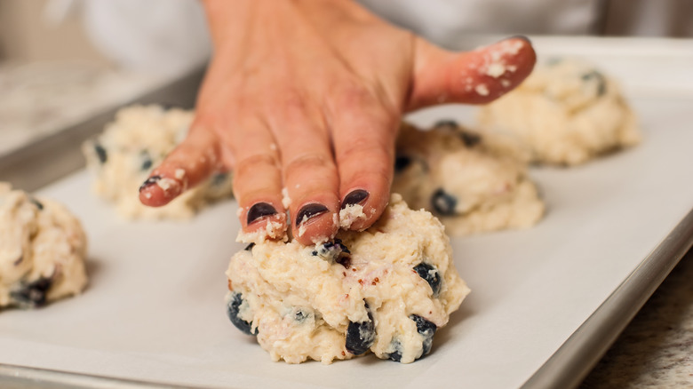 Person placing scones on tray