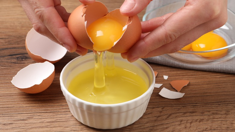 person separating yolk from egg white