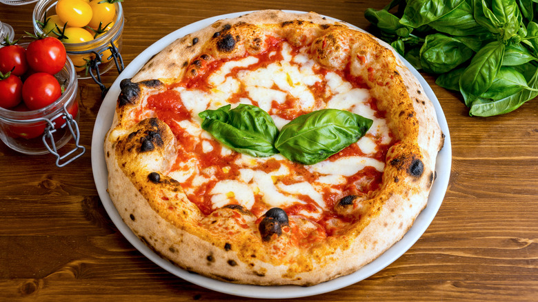 napoli pizza with produce on wooden table