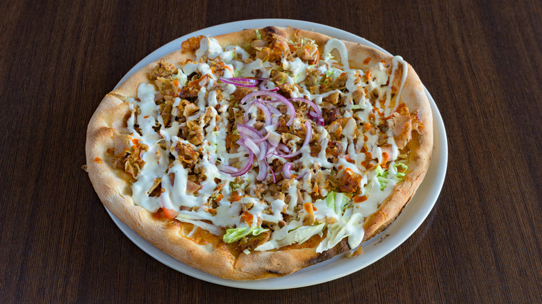 kebab pizza with yogurt sauce on wooden background