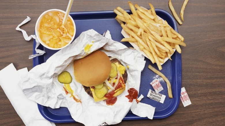 Burger, fries, orange soda on blue tray