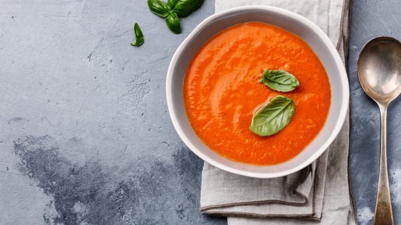 Bowl of tomato soup with basil leaves