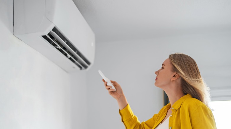 Woman turning on her air conditioner