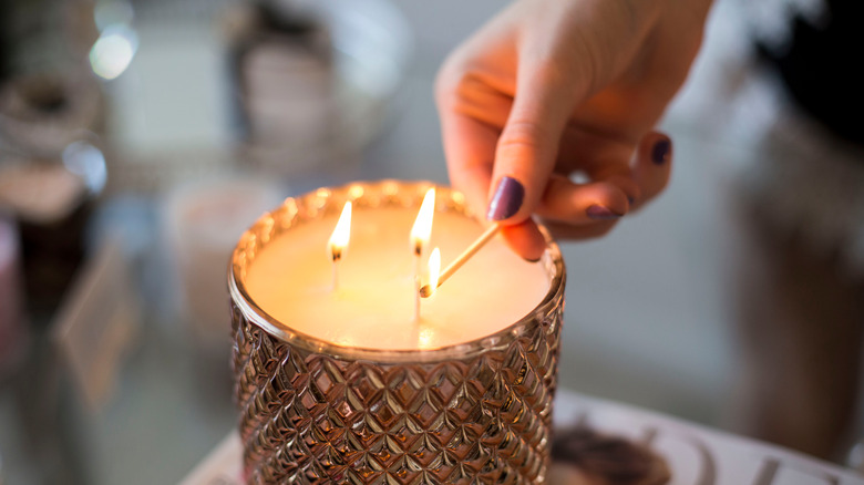 Hand lighting a three-wick candle