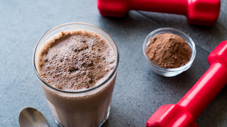 chocolate protein shake and red dumbbells