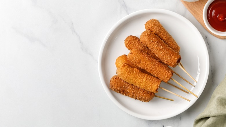 Corn dogs on white plate