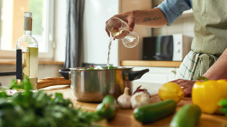 person pouring wine into pot