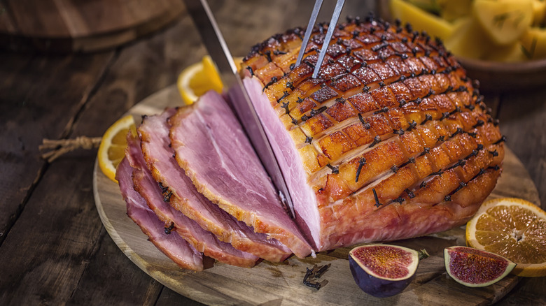 person slicing ham