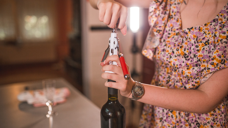 woman opening wine bottle
