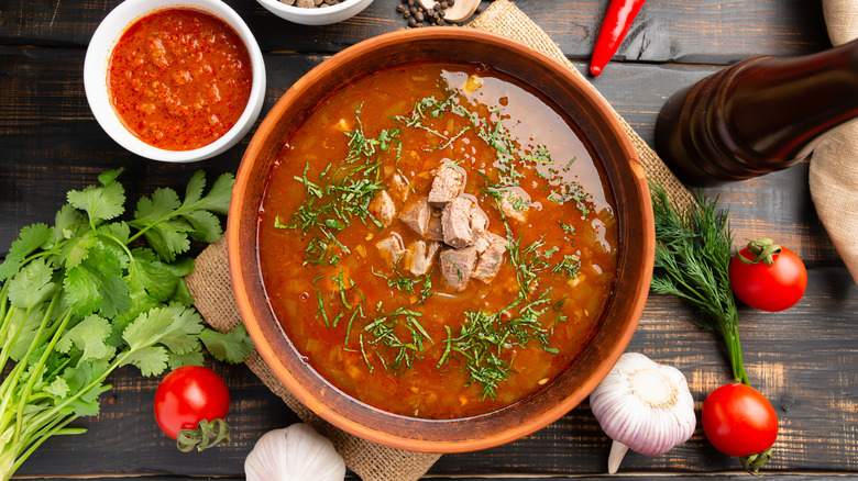 red soup next to cilantro and tomatoes