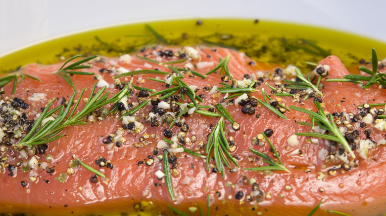 salmon marinating in oil and herbs