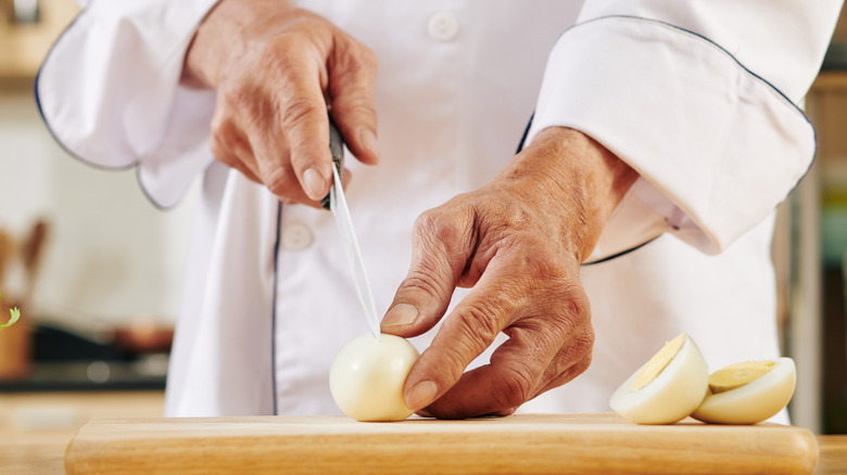Person slicing a boiled egg