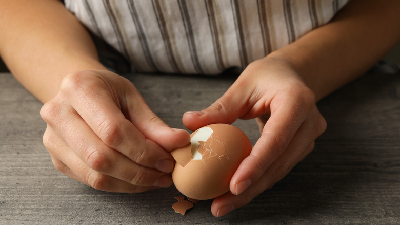 Person peeling an egg