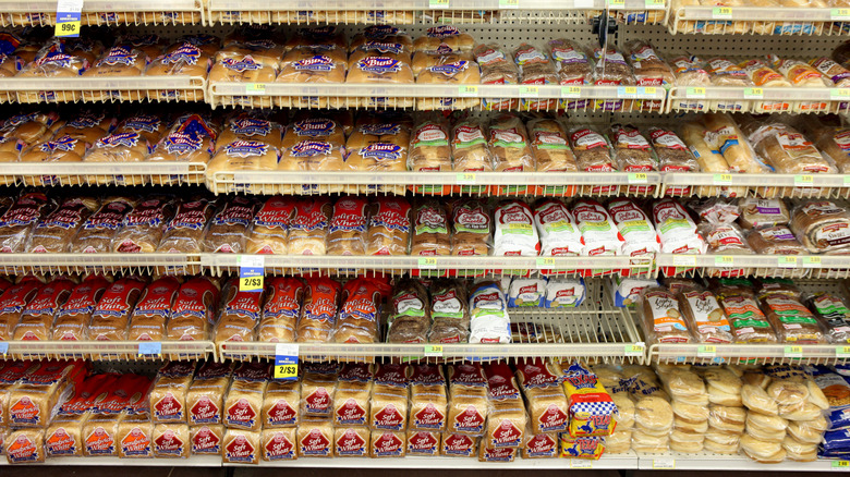 view of a grocery store bread aisle with many different kinds of bread brands