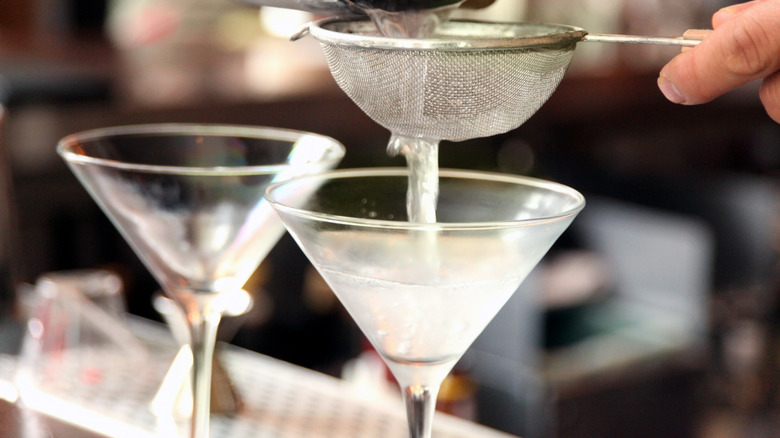 straining martini into cold glass