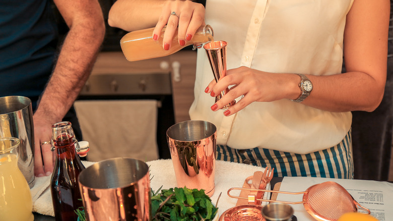 woman using cocktail jigger