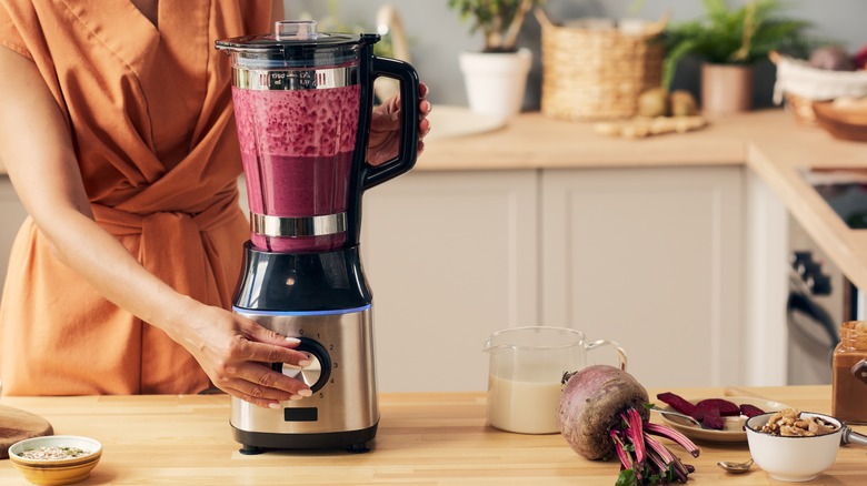 person mixing beets in blender