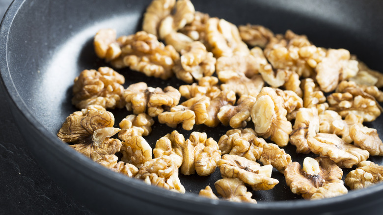 walnuts being toasted in pan