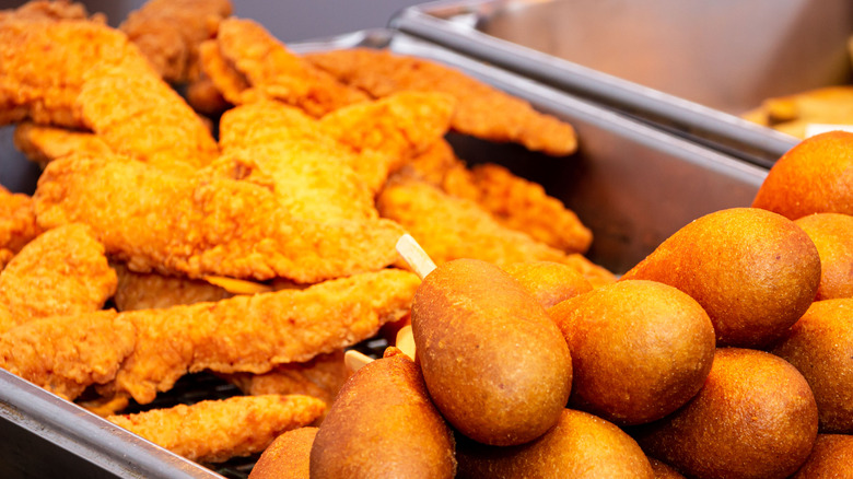 Corn dogs and chicken under heat lamp