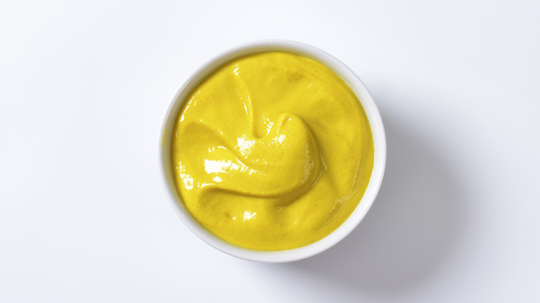 Bowl of mustard white background 