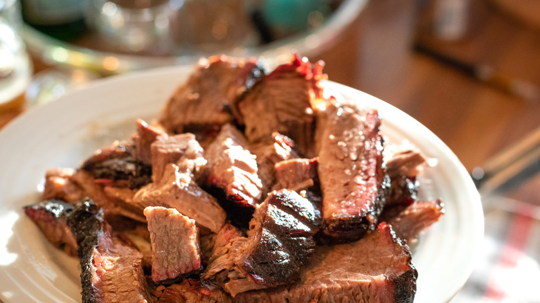 hand serving brisket on a plate