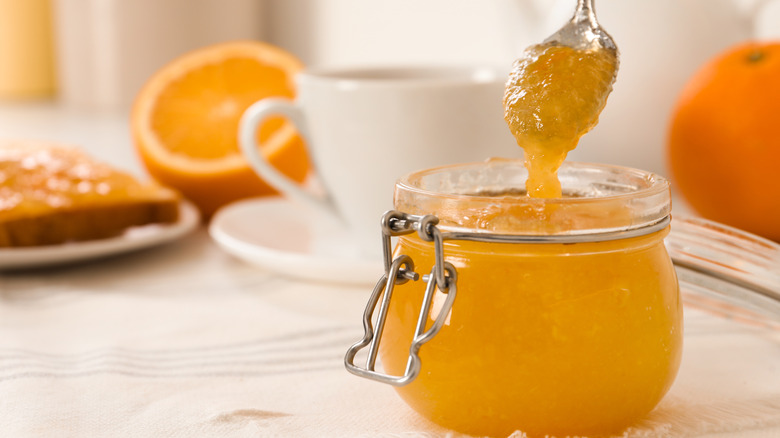 spoon of orange marmalade scooping out of a jar