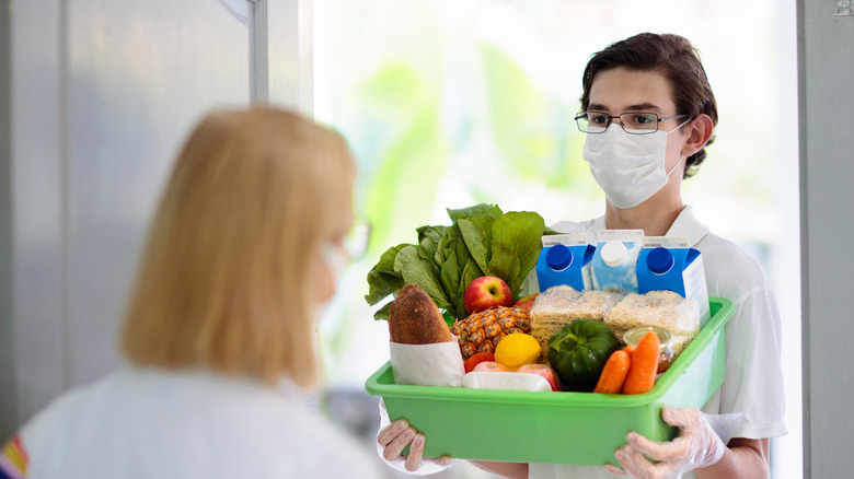 Person bringing groceries to door