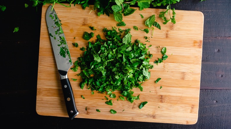 chopped herbs on wooden board