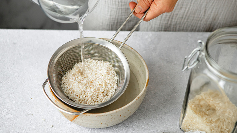 person rinsing white rice