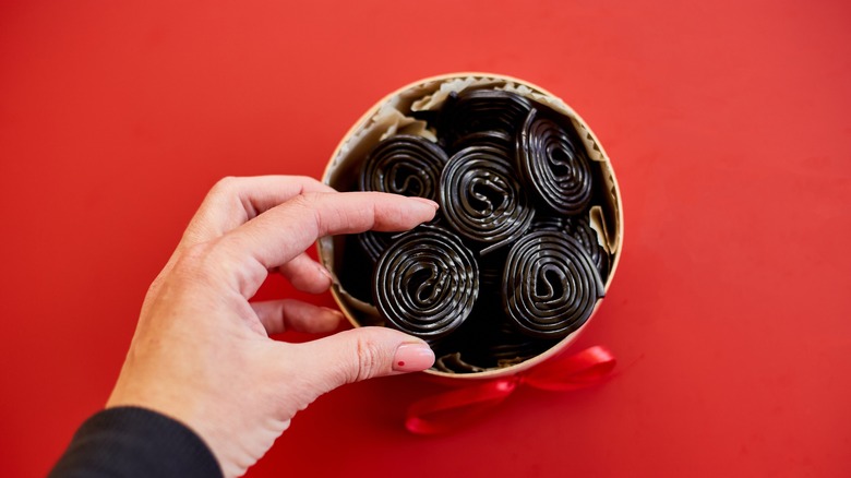 hand in black licorice bowl