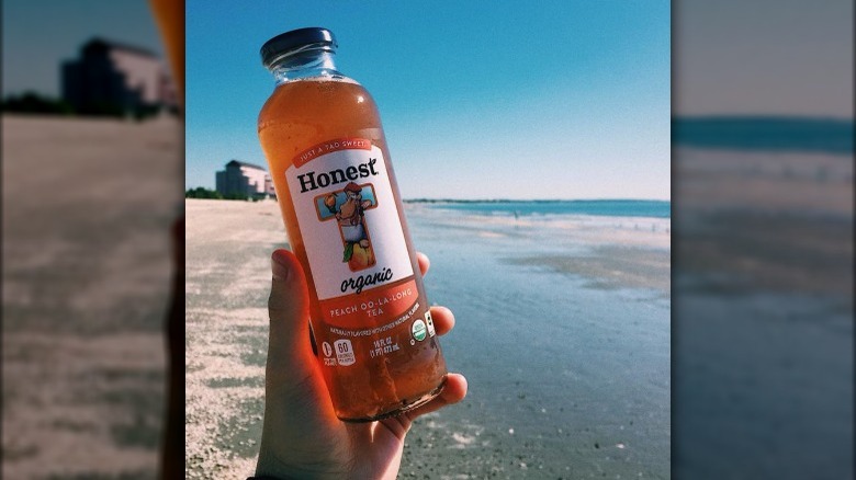 holding Honest Tea on beach