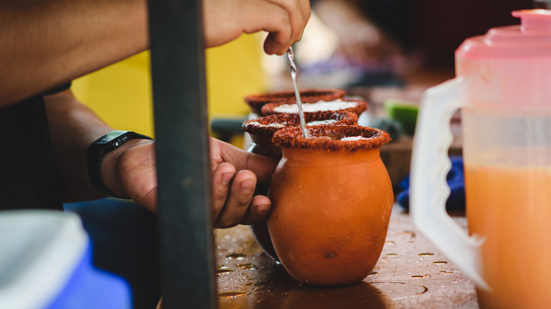 Person stirring cantarito in pot